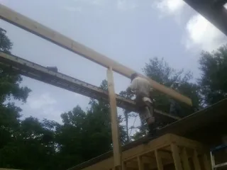 Carpenter setting a ridge beam over a new addition frame — Ice Dam Removal by Roofing Brothers in Shippingport