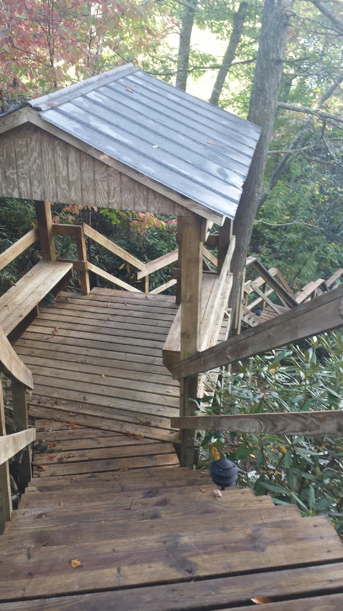 Metal roofed shelter over wooden steps on a wooded walkway — Skylight Repair & Installation work by our crew in Shippingport